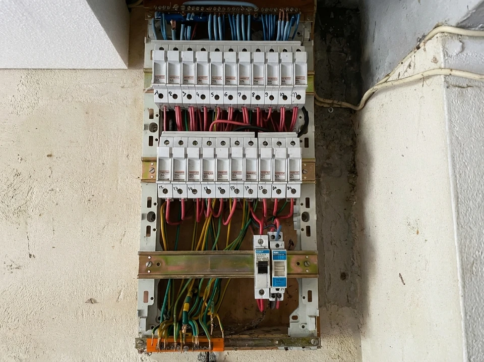Un électricien effectue des mesures électriques dans un tableau de distribution intérieur